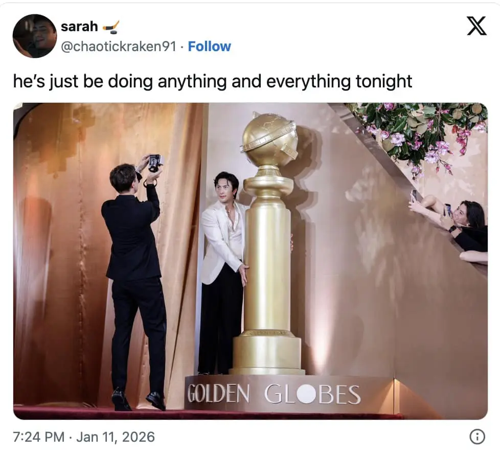 A 2026 Golden Globes meme showing an actor posing awkwardly with the giant golden globe statue.