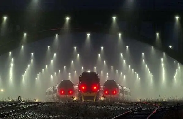 A creepy liminal space featuring trains with glowing red lights in a foggy rail yard.