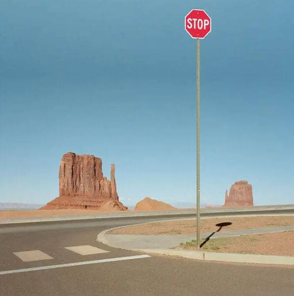 A creepy liminal space desert landscape featuring an unusually tall stop sign.