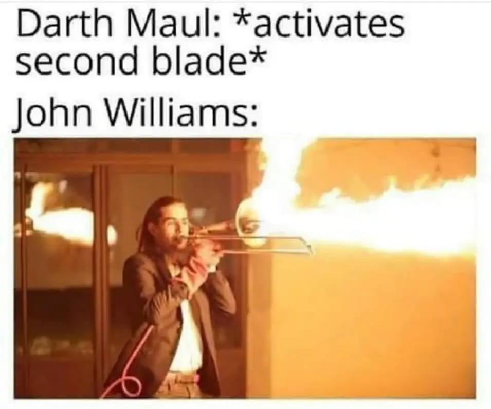 epic Darth Maul meme celebrating John Williams' legendary score. The top text notes the exact moment Maul activates his double-bladed lightsaber, paired with a photo of a musician playing a trombone that is shooting out a massive blast of fire to represent the intensity of "Duel of the Fates."