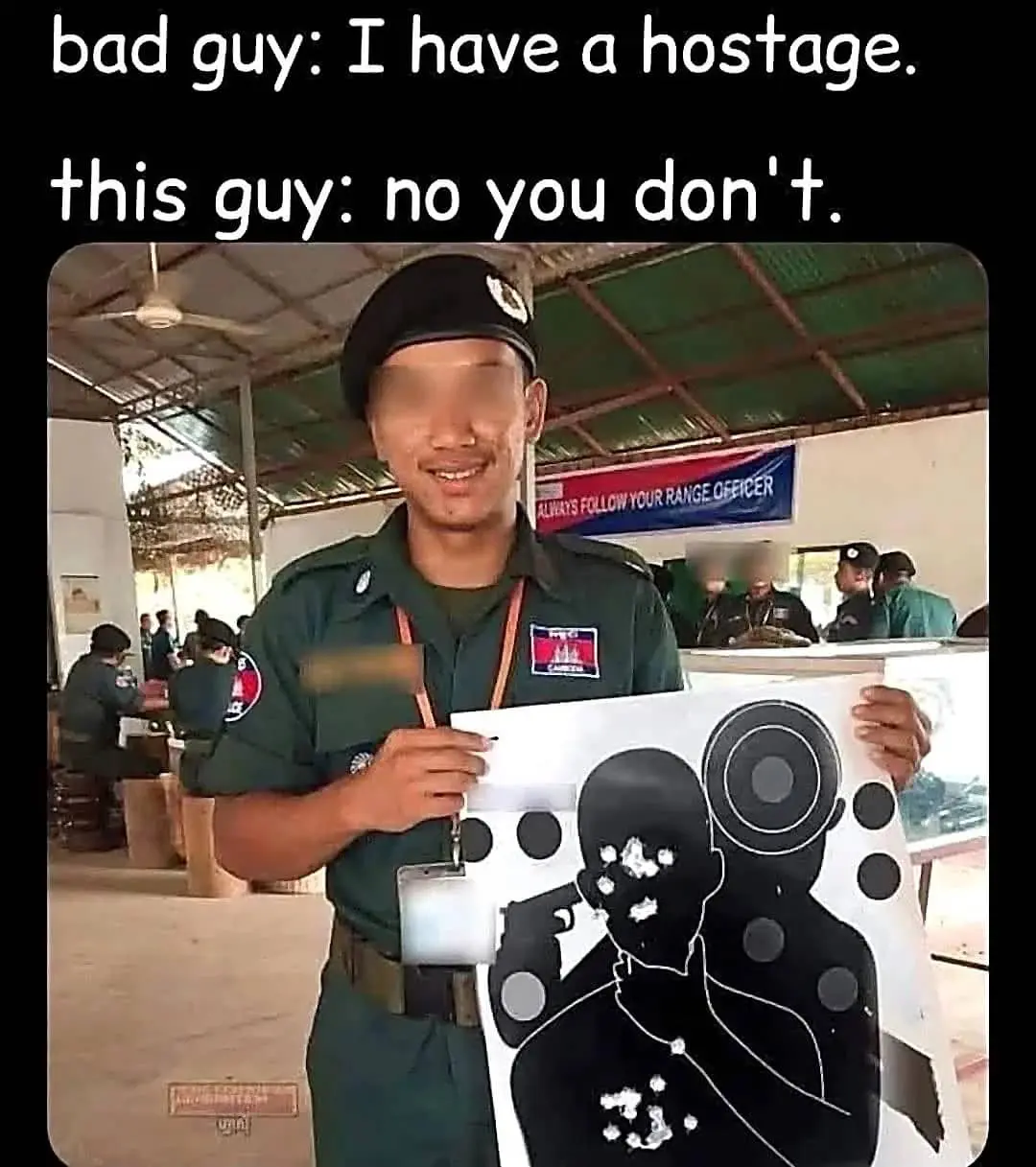 Soldier holding a paper shooting target with bullet holes concentrated on the hostage figure's face.