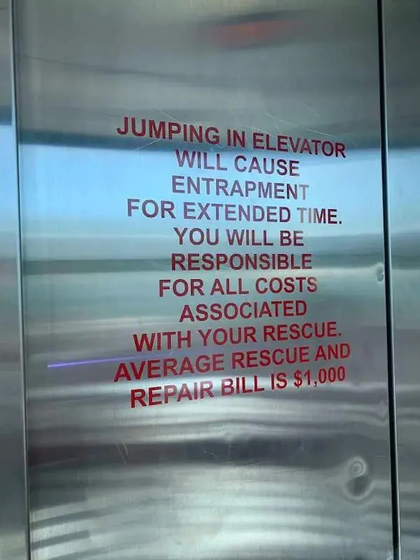 A stern but funny osha violation picture of a sign inside an elevator warning that jumping will cause "entrapment for extended time" and result in a $1,000 rescue bill.