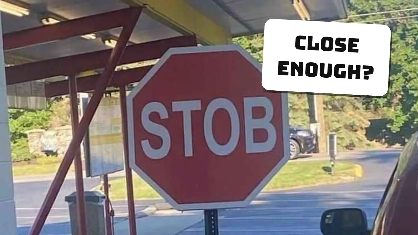 Red stop sign misspelled as STOB standing on a yellow base outside a drive-in, one of the classic spelling fails.