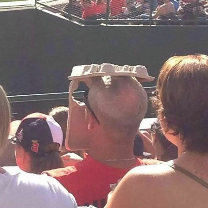 Weird Hats beer carton on guys head at baseball game