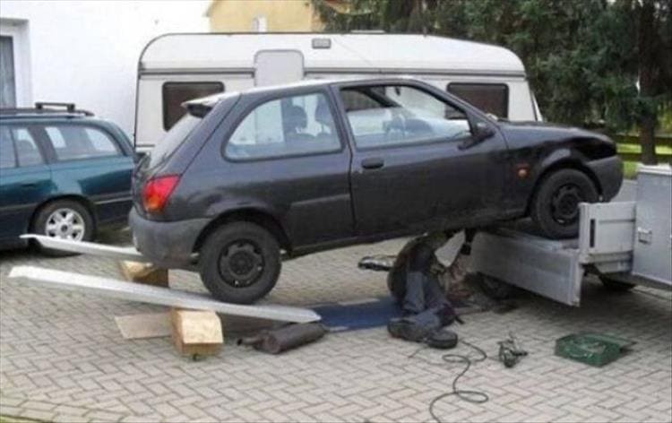 car on very unsafe ramps while mechanic underneath
