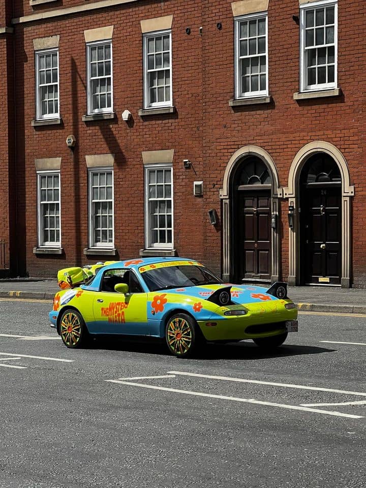 funny miata, miatas with threatening auras, comedic roadster bits, small convertible jokes, quirky sports car humor, Miata memes, comedic two-seater illusions, beloved tiny ride references, Mazda jokes, brand-based comedic angles, automaker witty bits, car humor, vehicular comedic lines, automotive meltdown commentary