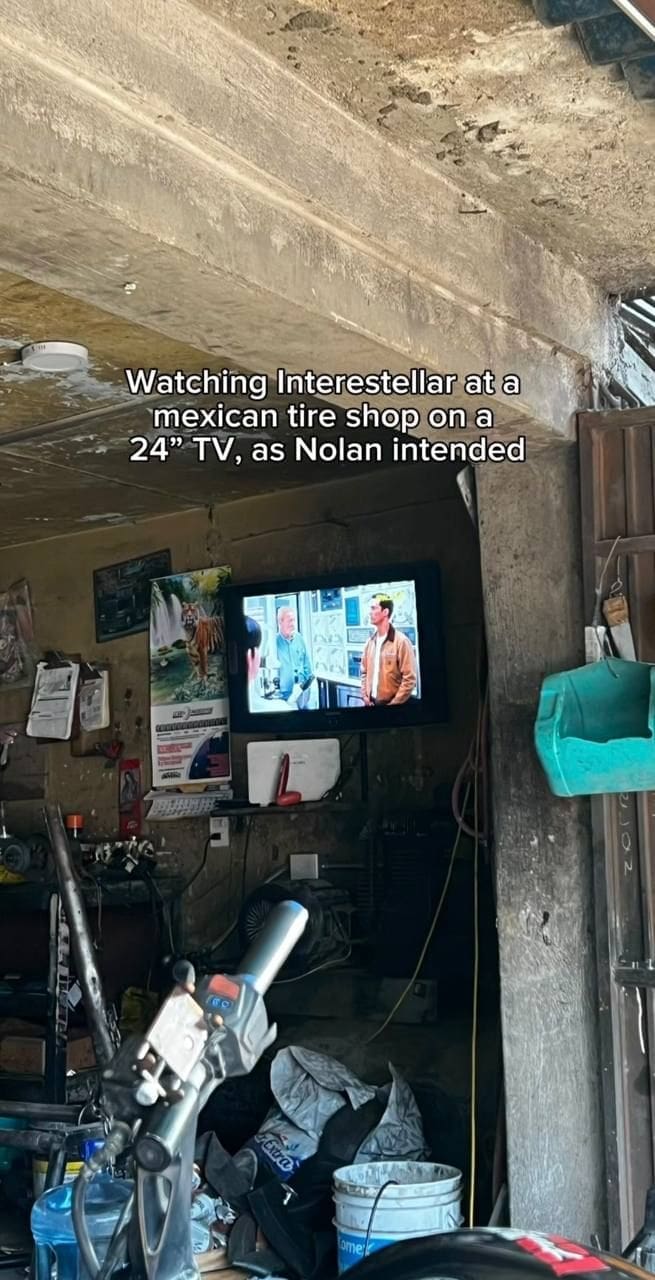 Small TV in cluttered shop plays Interstellar with ironic meme caption