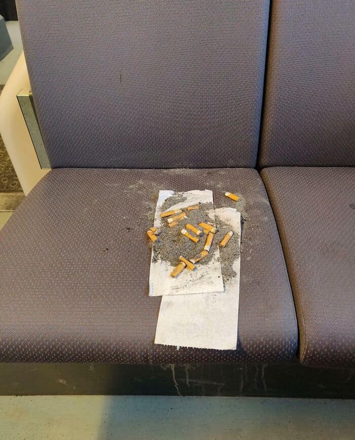 Cigarette butts and ashes on bus seat.
