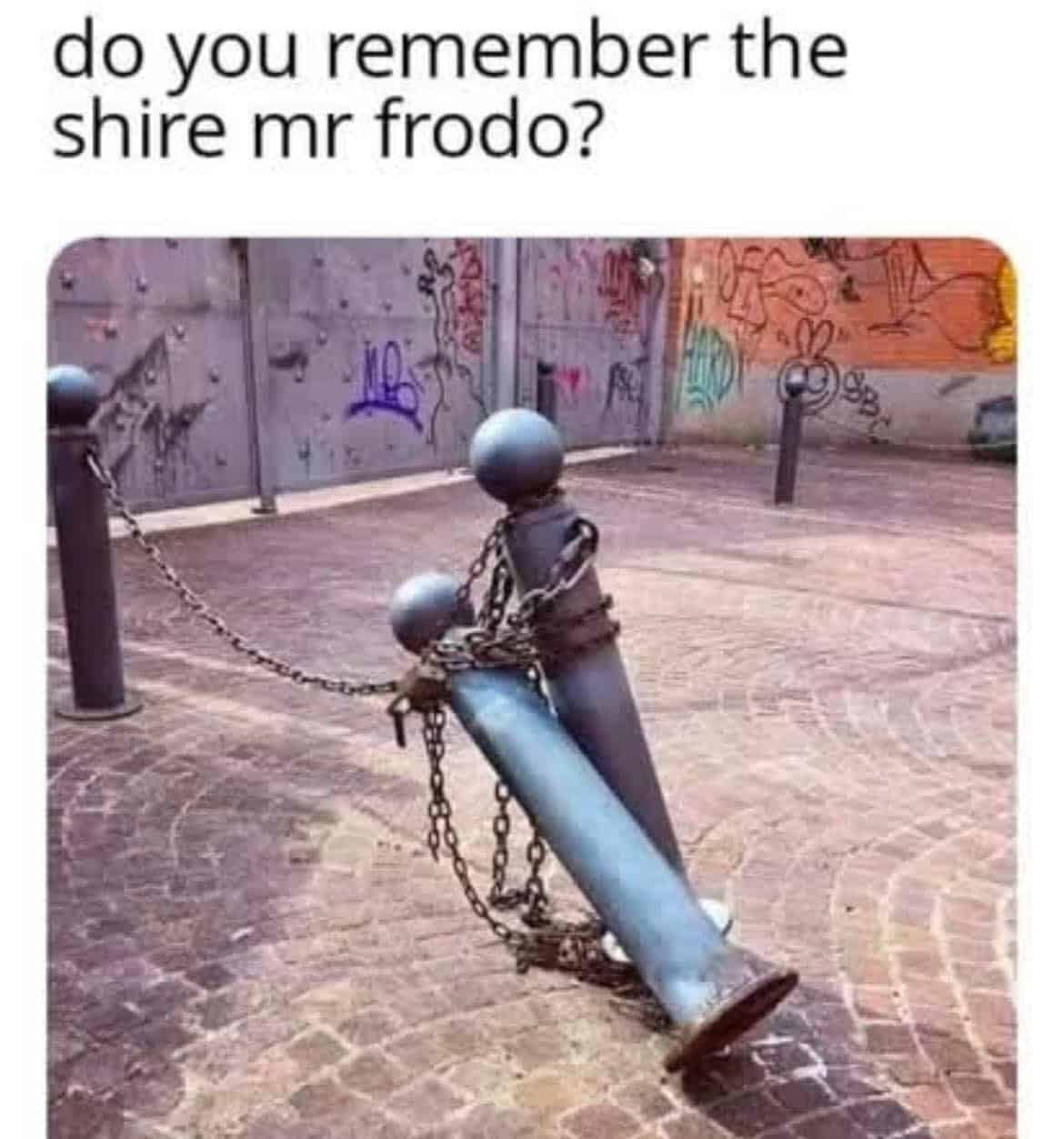 Two chained street bollards resemble one kneeling to embrace another on a cobbled plaza, like a sorrowful reunion.