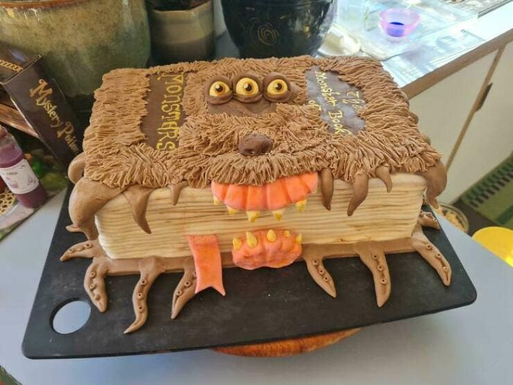 Monster Book of Monsters cake with fur, eyes, teeth, and a lolling tongue.