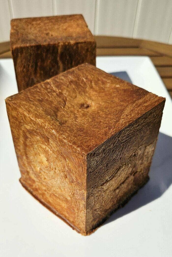 Two cube-shaped loaves of bread with deeply caramelized crusts.