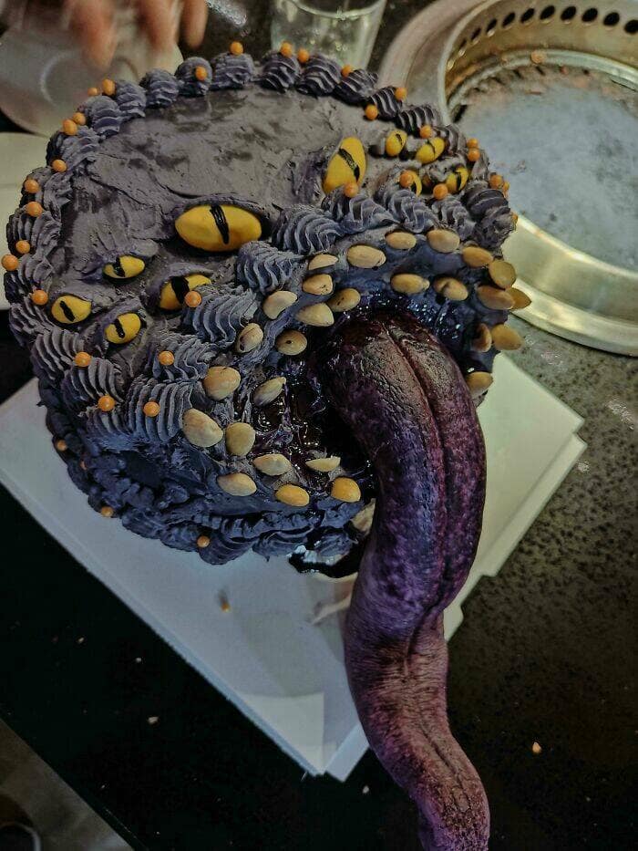 Monstrous purple cake with many yellow eyes and an extra-long tongue.