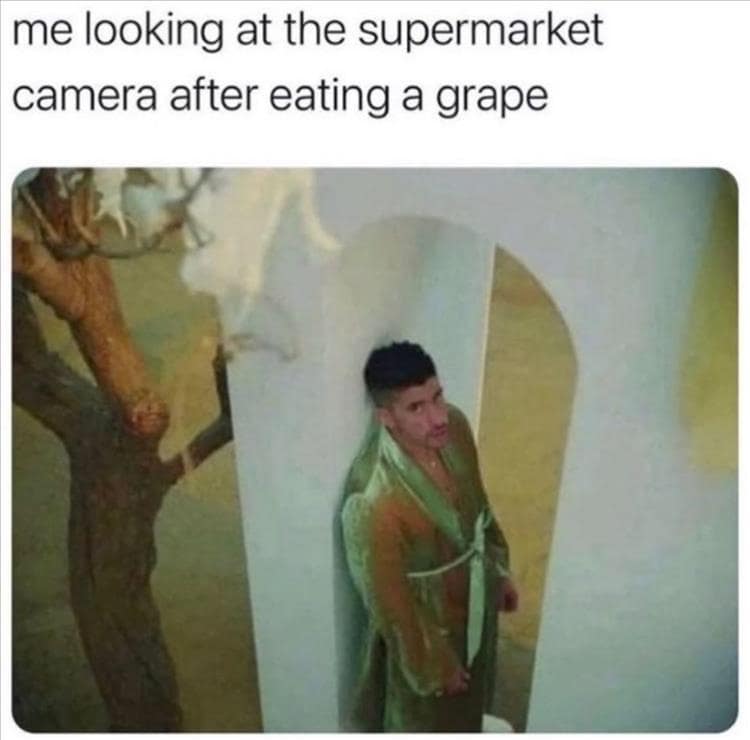 Classic meme of a man in a green robe guiltily staring up at a supermarket security camera after eating a grape.