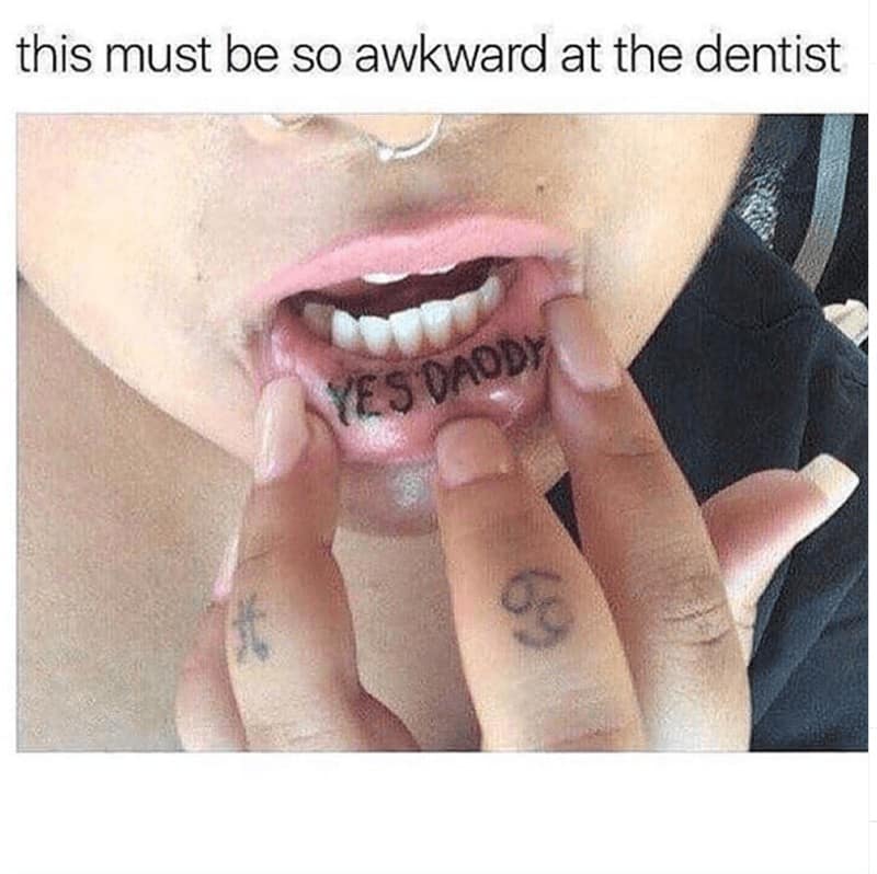 Close-up of lip tattoo reading “Yes Daddy” with dentist meme caption.