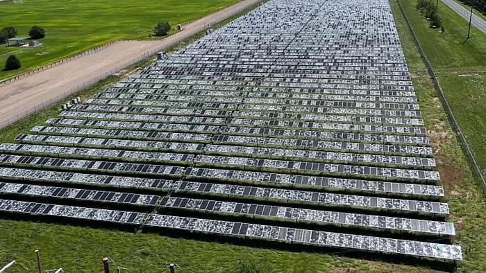 A massive solar farm with thousands of panels completely shattered from hail damage.