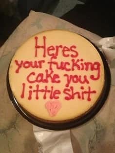 A funny cake with a very aggressive and rude message written in red icing.