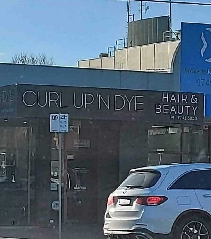 A funny pic of a hair salon with the clever, dark humor pun name "Curl Up 'N' Dye."