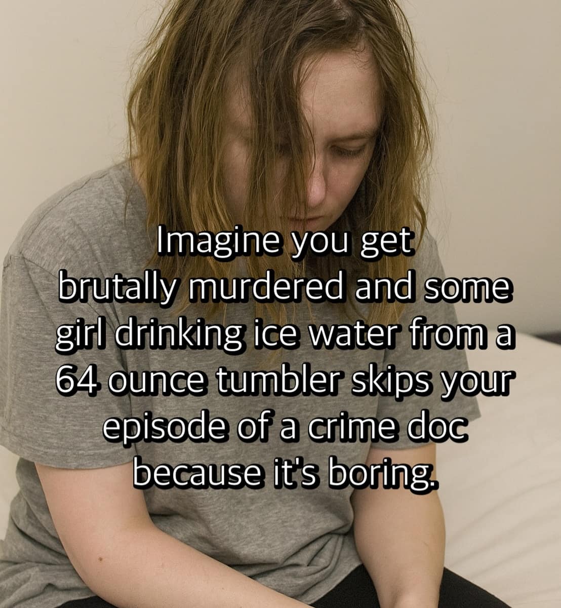 A somber woman sits on a bed looking downcast. The overlay text reads: “Imagine you get brutally murdered and some girl drinking ice water from a 64 ounce tumbler skips your episode of a crime doc because it’s boring.”