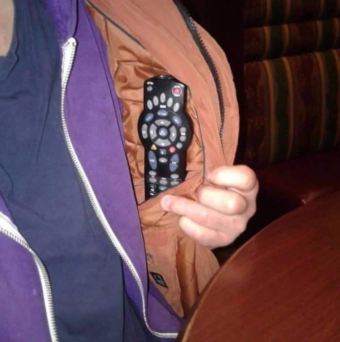 Man showing off a remote hidden in his jacket’s secret pocket, a slice of redneck ingenuity in action.