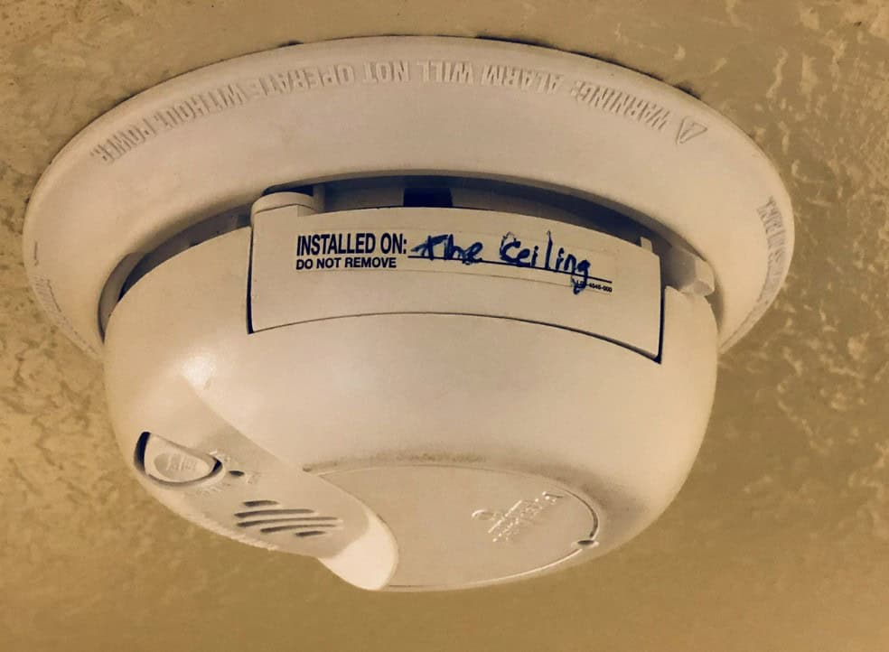 A funny "you had one job" fail where someone wrote "The Ceiling" on a smoke detector installation label.