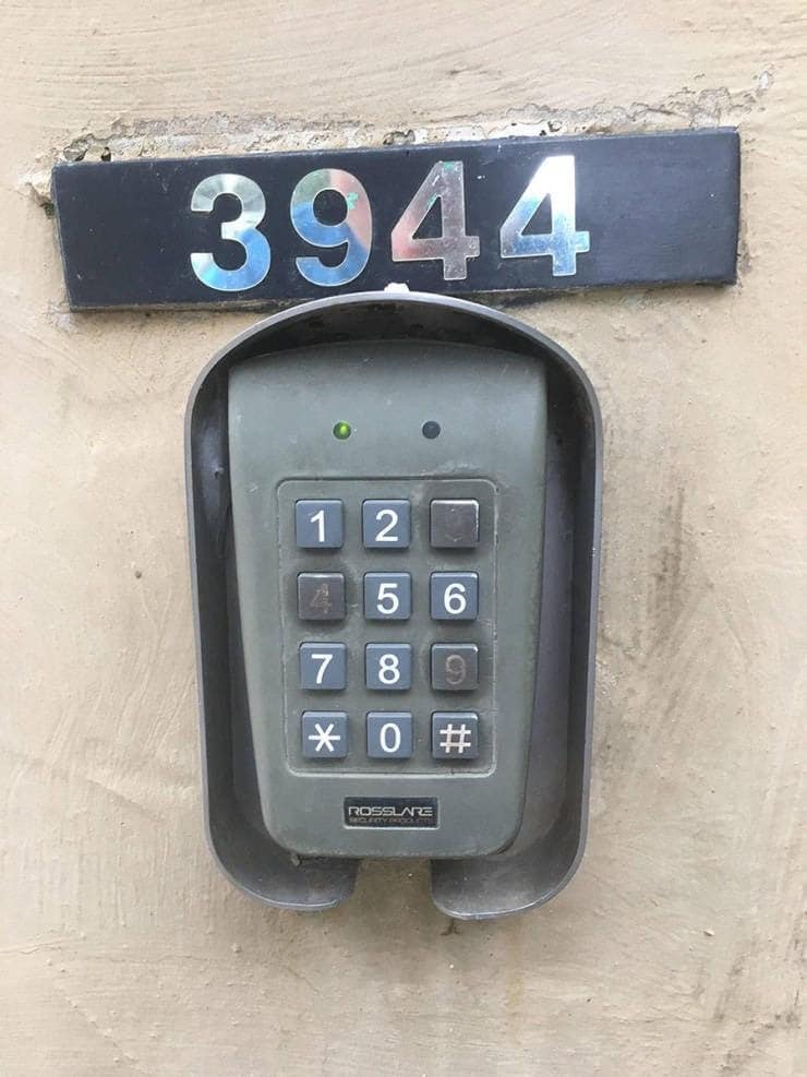 A "you had one job" fail where a building's entry keypad was installed over the house number.