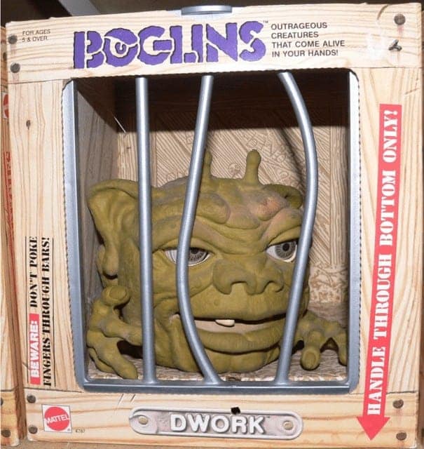 A creepy and cool Boglins hand puppet named Dwork in its cage-like 80s toy box.