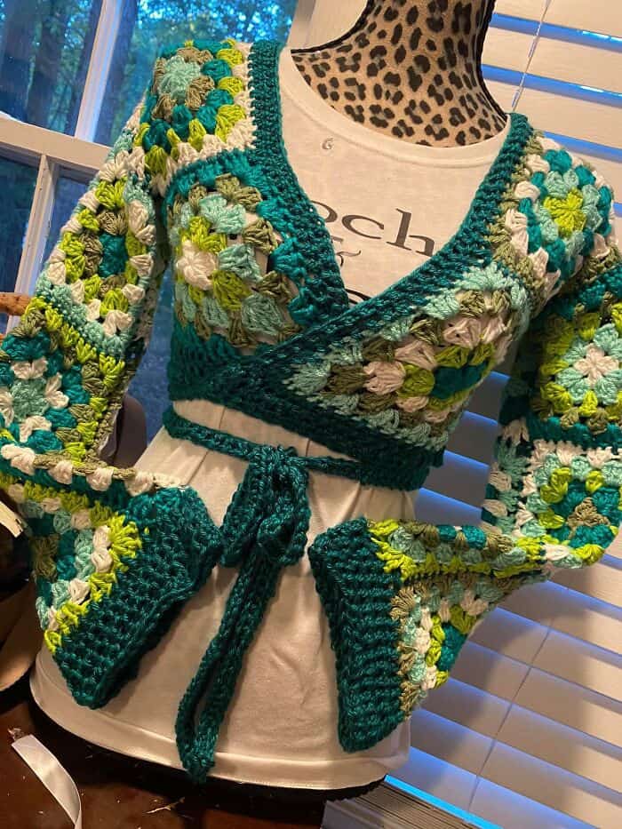 An amazing crochet granny square wrap top with bell sleeves in shades of green.