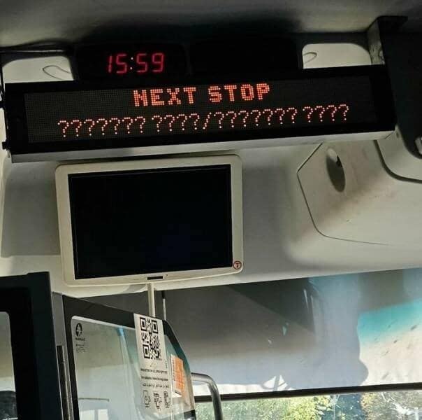 The digital "Next Stop" display sign on a public bus that has malfunctioned and is only displaying a long and unhelpful string of question marks.