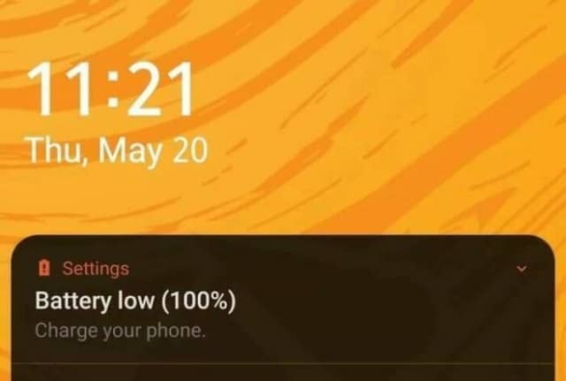 A confusing and contradictory smartphone notification that is warning the user about a "Battery low" status while showing that the battery is at 100% charge.