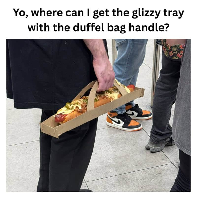 A funny food meme of a man carrying a giant, loaded hot dog in a "glizzy tray with a duffel bag handle."
