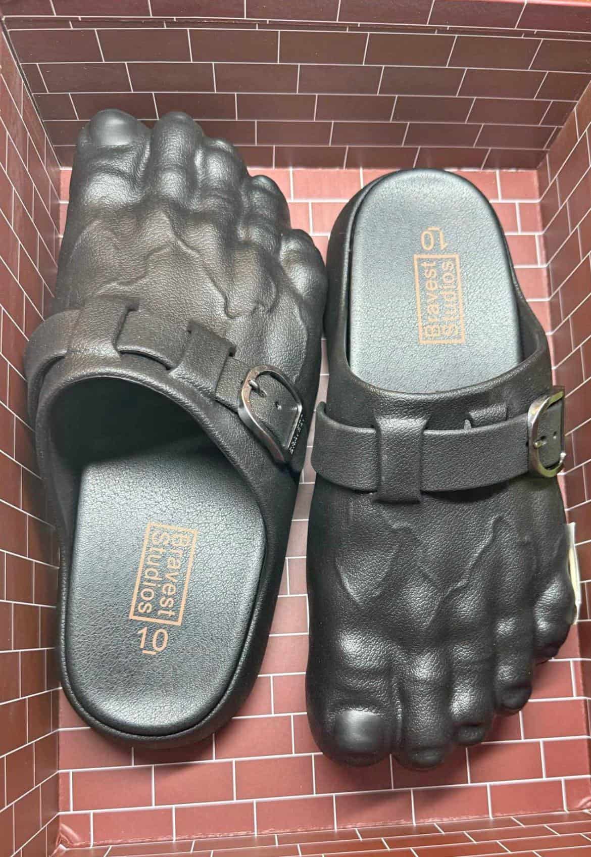 A cursed image of a pair of black sandals designed to look like monstrous, giant feet.