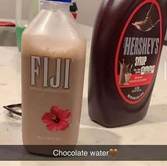 A food meme of a cursed food image, showing chocolate syrup mixed with water in a Fiji bottle.