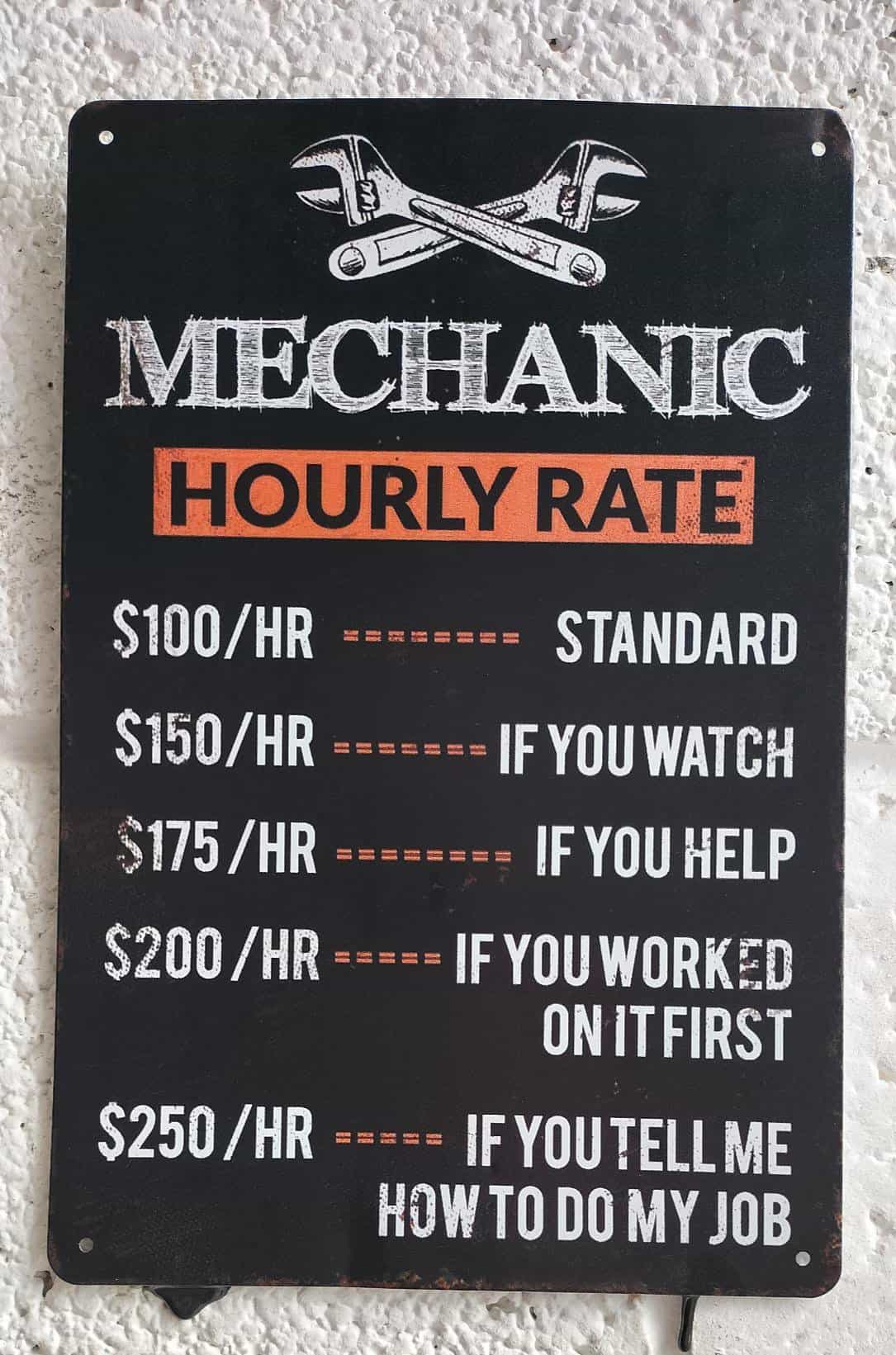 A funny sign at a mechanic's shop listing an hourly rate that increases if you watch, help, or give advice.