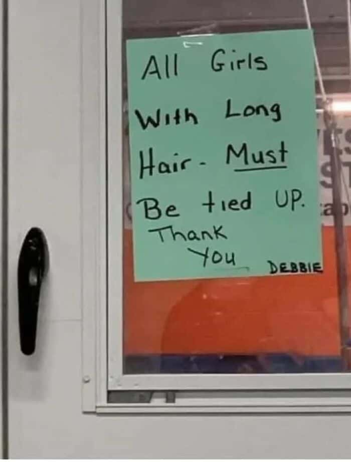 A funny sign with unfortunate phrasing that reads, "All Girls With Long Hair - Must Be tied UP."