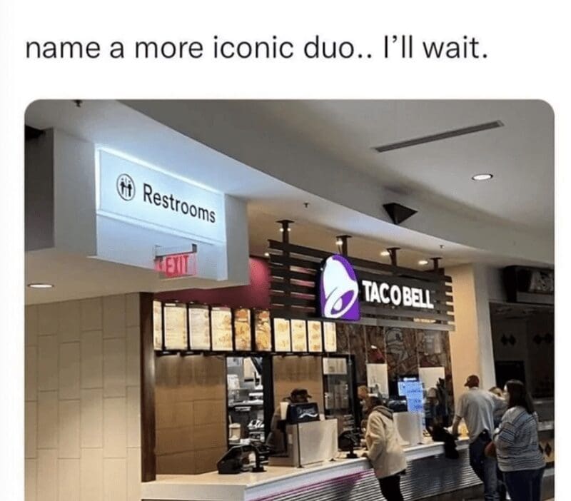 A funny and relatable photo of a Taco Bell fast-food location that is very conveniently located right next to the public restrooms in a shopping mall food court.