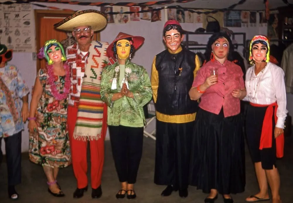 A color photograph from what appears to be a 1960s or 1970s Halloween party, where a group of white people are all dressed in very offensive and racist Halloween costumes.