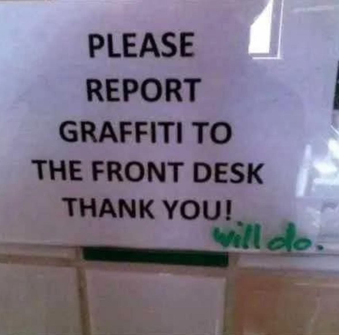 A piece of wholesome graffiti where someone writes "will do." on a sign that asks people to report graffiti.