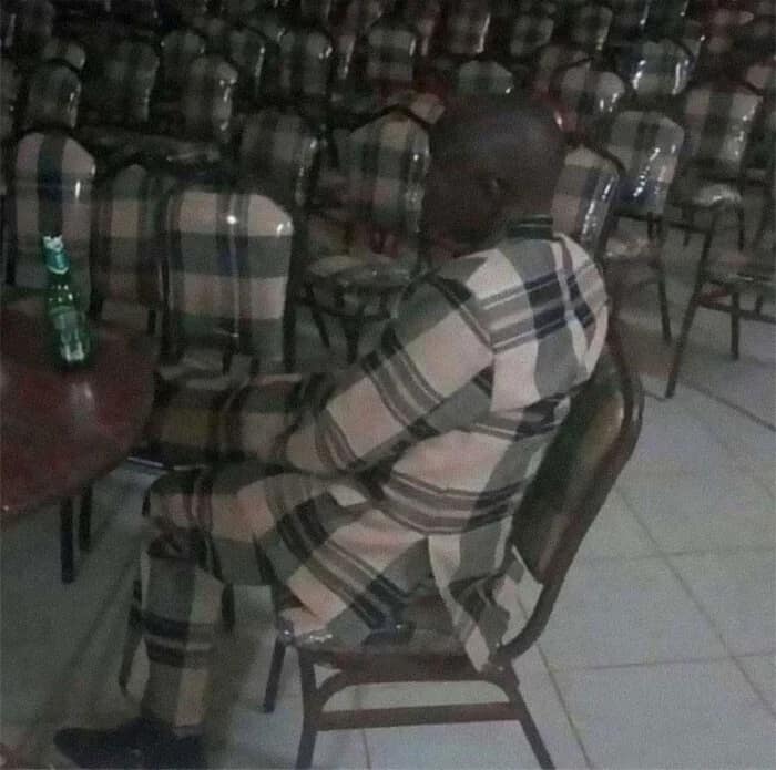 Incredible accidental camouflage example showing a man whose plaid suit perfectly matches the chairs around him