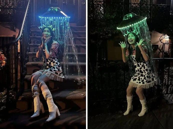 A woman wearing a fun cow costume being "abducted" by a light-up UFO beam decoration.