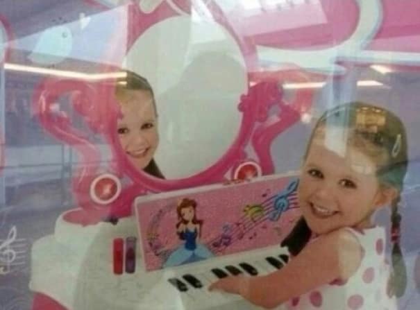 Creepy funny photoshop fail in a toy advertisement where the child's reflection in the mirror doesn't match.