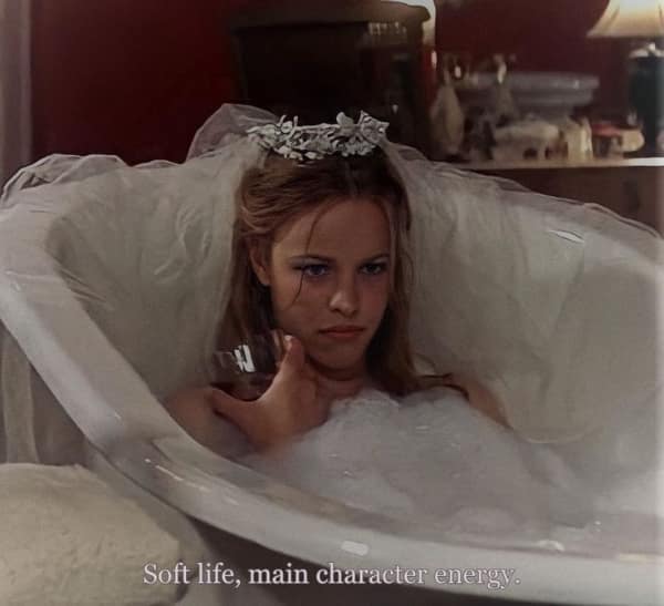 Rachel McAdams as Allie in The Notebook, lying sadly in a bathtub wearing a wedding tiara, captioned "main character energy."