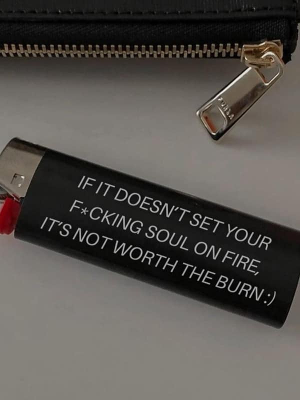 A black lighter engraved with the intense quote "IF IT DOESN'T SET YOUR F*CKING SOUL ON FIRE, IT'S NOT WORTH THE BURN."