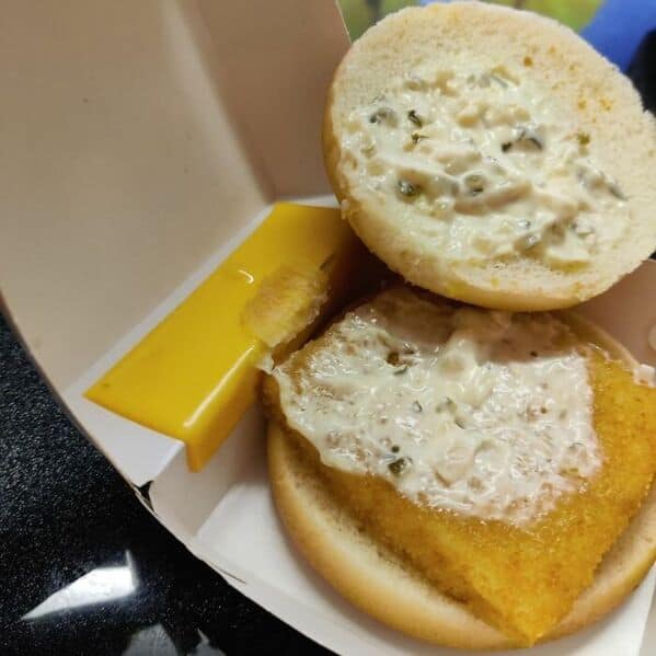A picture of a deconstructed Filet-O-Fish where the sad half-slice of cheese is stuck to the box.