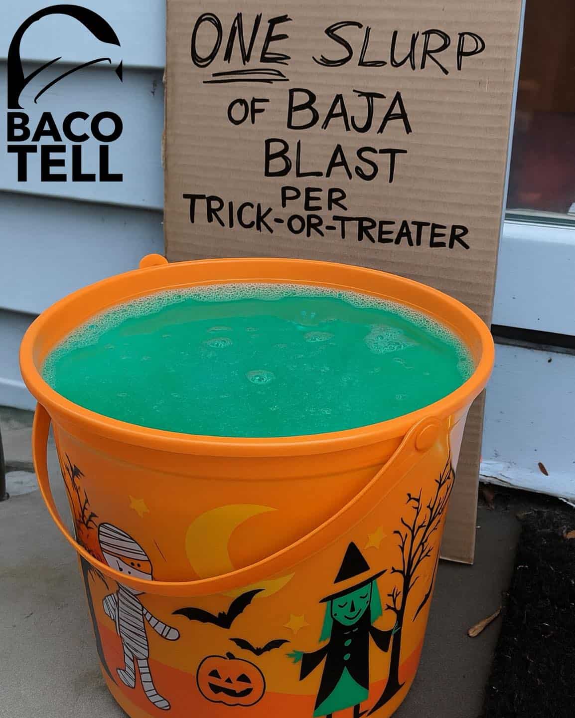 A funny Halloween photo of a trick-or-treat bucket filled with Baja Blast, with a sign allowing one slurp per person.