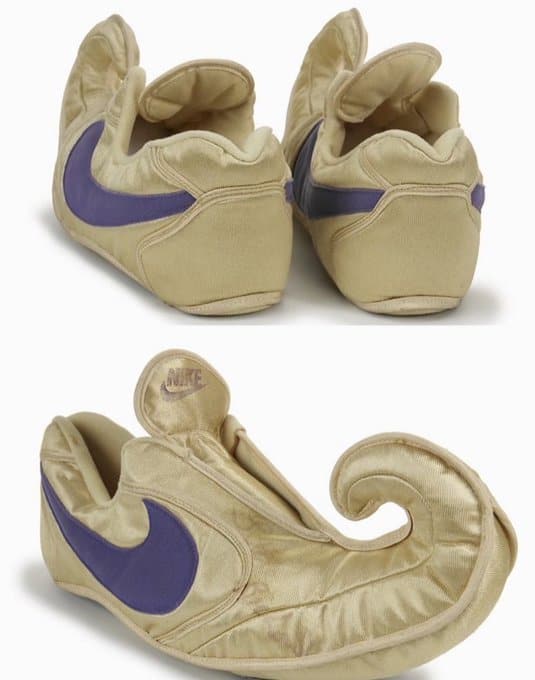 Gold Nike sneakers with curled toes shaped like genie or elf shoes.