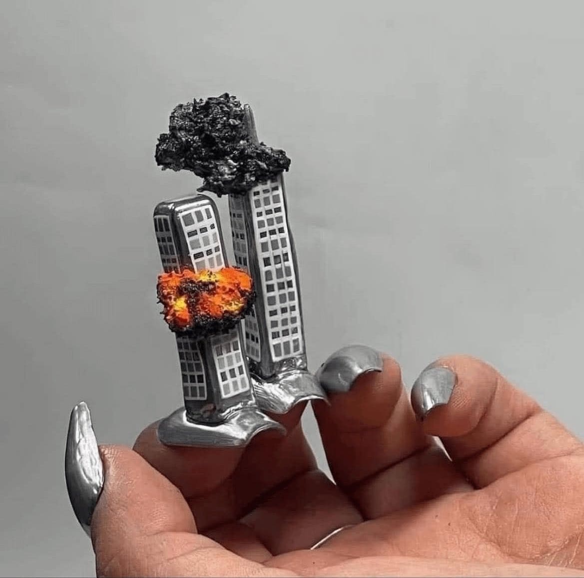 3D acrylic nail art depicting the Twin Towers on fire with smoke effects.
