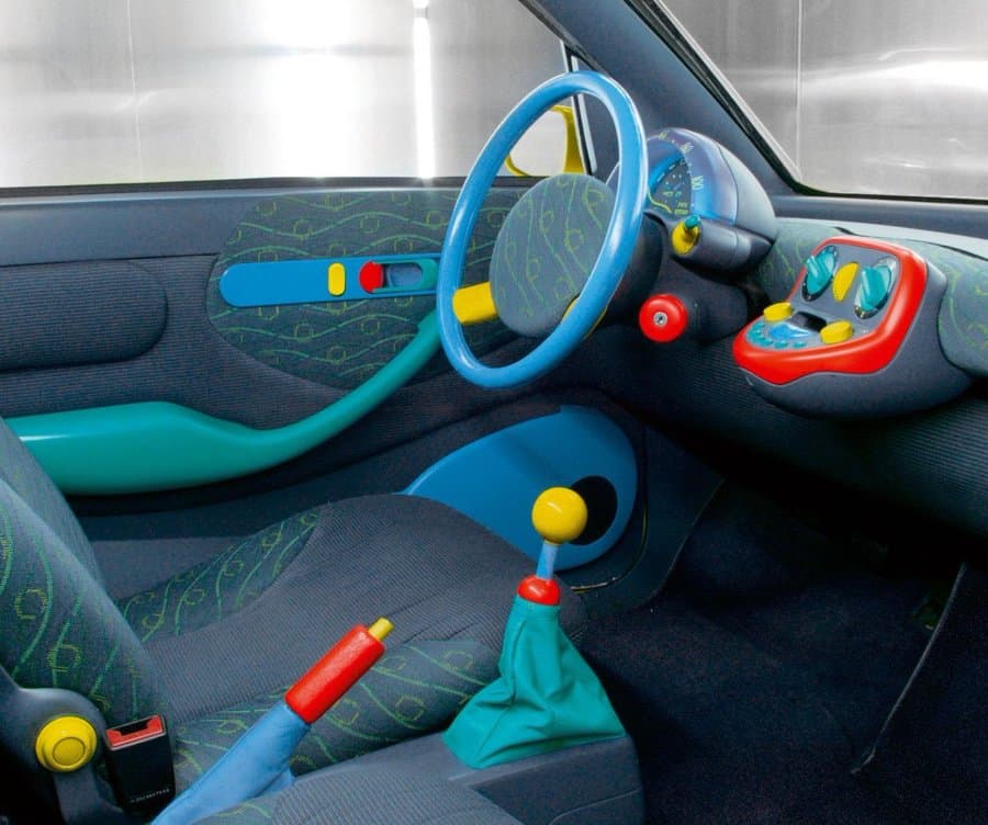 Vintage Renault Twingo car interior with colorful green, blue, and yellow dashboard controls.