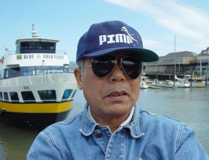 A man wearing a "PIMA" baseball cap, a funny knock off brand of the Puma logo.