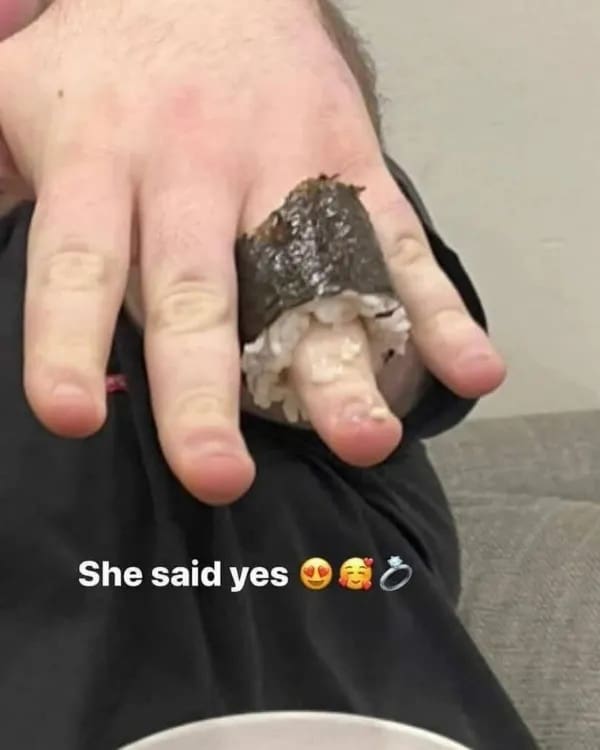 Sushi roll placed on finger looking like an engagement ring funny memes.