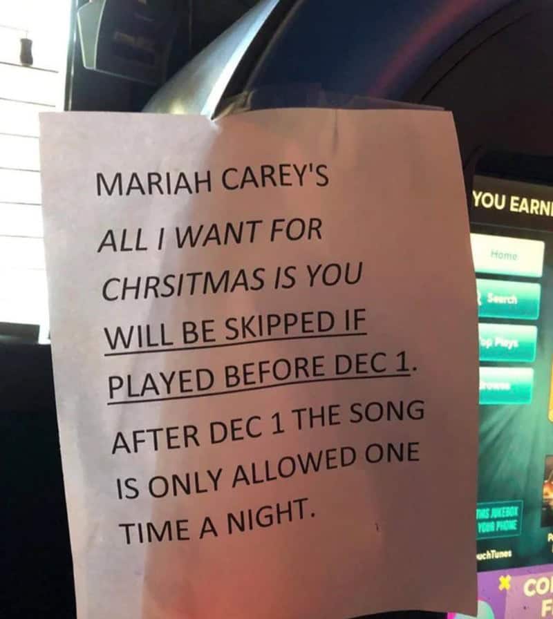 A funny sign on a jukebox, warning that Mariah Carey's Christmas song will be skipped if played before December 1st.